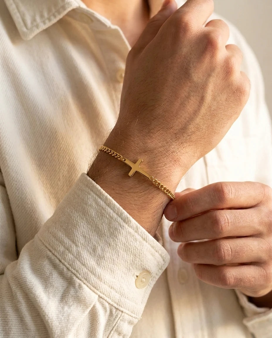 Gold Stellan sideways-cross bracelet worn with a cream shirt