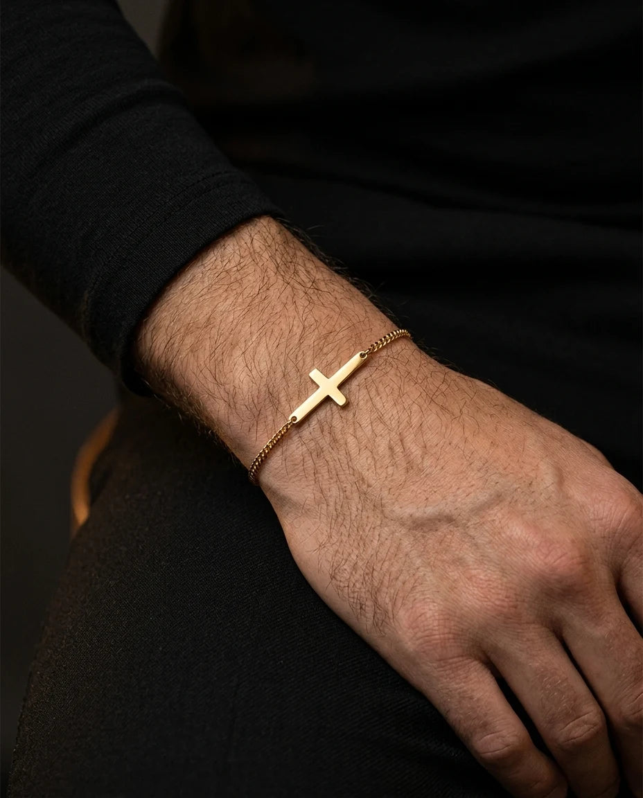 Gold Stellan bracelet on a wrist, black sweater, seated