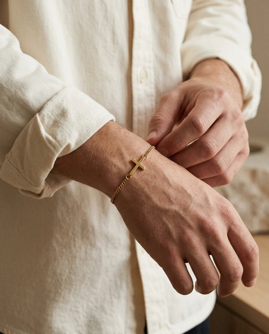 Gold Stellan bracelet while adjusting a cream shirt cuff